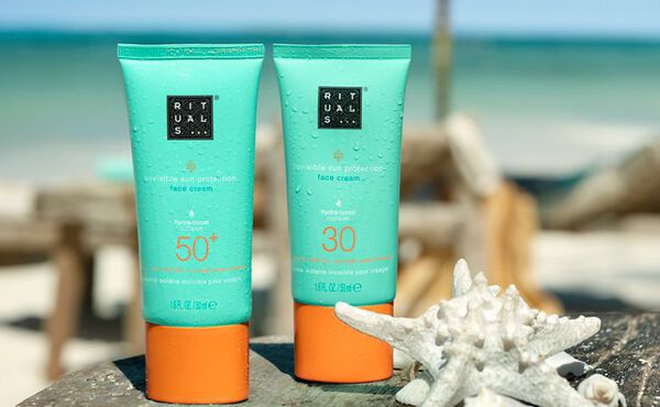 The Ritual of Karma SPF 30 and SPF 50 face sunscreens on a beach.